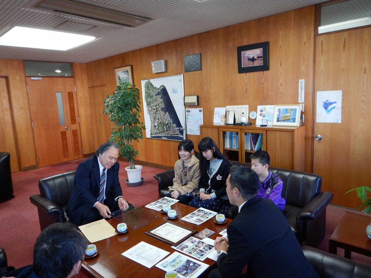 今川こども自然クラブのこどもたちが市長に日頃の活動内容の説明や全国フェスティバルの様子などを報告をしている写真