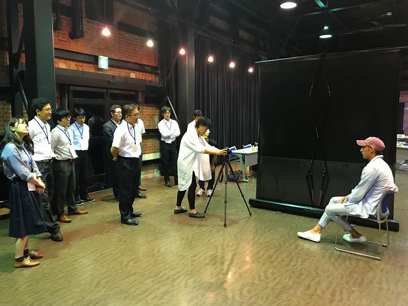 カメラを使って撮影のイメージについて話し合っている写真